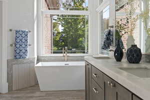 Bathroom featuring vanity, hardwood / wood-style flooring, and a washtub