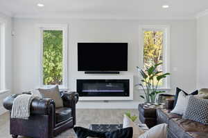 Living room with a wealth of natural light, ornamental molding, and light wood-type flooring