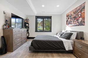 basement bedroom #7 featuring crown molding and light wood-type flooring