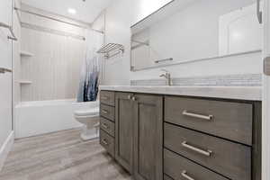 full  bathroom featuring vanity, toilet, shower / tub combo, and hardwood / wood-style floors