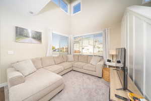 Carpeted living room with a high ceiling