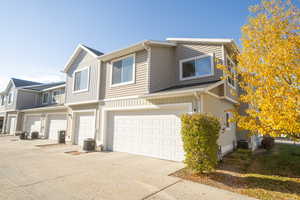 View of front of house with cooling unit and a garage