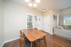 Dining space featuring dark laminate floors and a chandelier