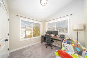 Bedroom featuring vaulted ceiling and light carpet