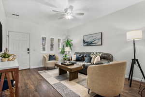 Living room with ceiling fan and dark hardwood / wood-style flooring