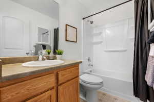 Full bathroom with vanity, shower / tub combo, and toilet