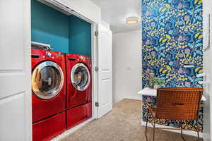 Laundry room featuring carpet flooring and washing machine and clothes dryer