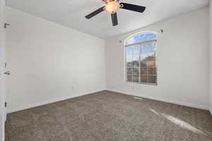 Carpeted spare room featuring ceiling fan