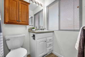 Bathroom with vanity, hardwood / wood-style floors, and toilet