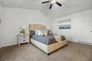 Bedroom featuring light carpet, vaulted ceiling, and ceiling fan