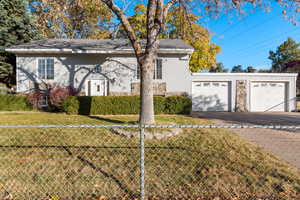 View of front of home with a garage and a front lawn