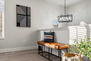 Sitting room featuring a notable chandelier, wood-type flooring, and a wealth of natural light