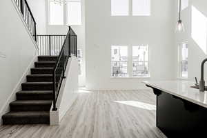 Stairway with sink, a high ceiling, and wood-type flooring