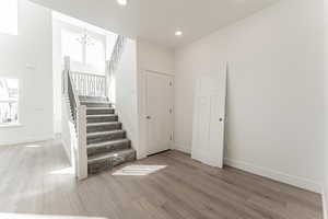 Stairs featuring a notable chandelier and wood-type flooring