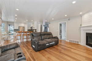 Living room with light hardwood / wood-style flooring and wooden ceiling