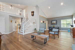 Living room featuring high vaulted ceiling and light wood-type flooring