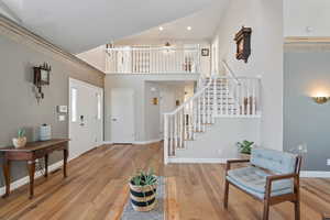 Entrance foyer featuring light hardwood / wood-style flooring and a towering ceiling