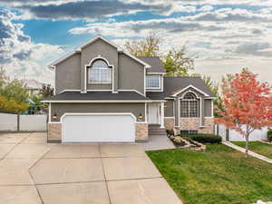 View of front of property featuring a front lawn and a garage