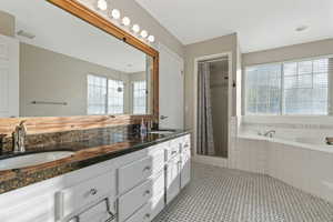 Bathroom featuring vanity, tile patterned flooring, and plus walk in shower