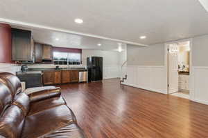 Living room featuring sink, a textured ceiling, and dark hardwood / wood-style flooring