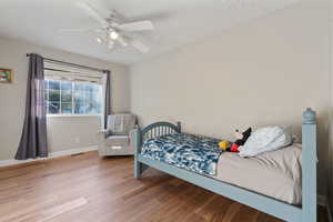 Bedroom with hardwood / wood-style floors and ceiling fan