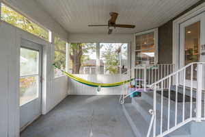 Unfurnished sunroom with ceiling fan