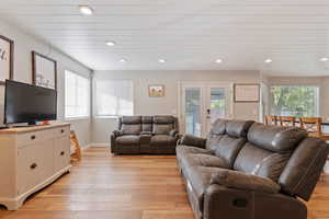 Living room with french doors and light hardwood / wood-style flooring