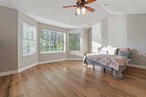 Bedroom featuring ceiling fan, lofted ceiling, and light wood-type flooring