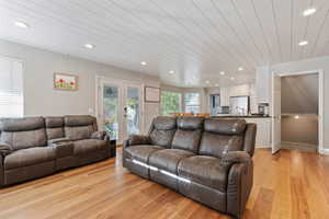 Living room with wood ceiling, french doors, and light wood-type flooring