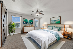 Bedroom with ceiling fan, a textured ceiling, and a barn door, Virtually Staged