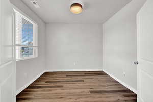 Unfurnished room featuring dark wood-type flooring