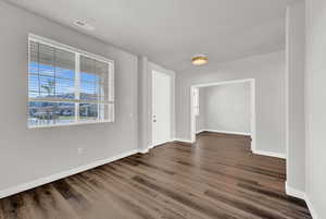 Spare room featuring a textured ceiling and dark hardwood / wood-style floors