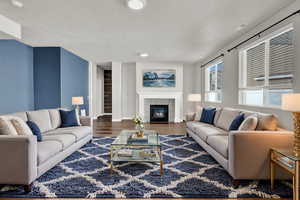 Living room with hardwood / wood-style flooring and a tiled fireplace, Virtually Staged