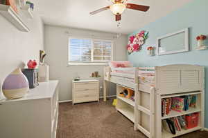 Bedroom with ceiling fan and dark carpet