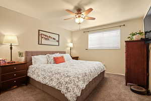 Carpeted bedroom with ceiling fan