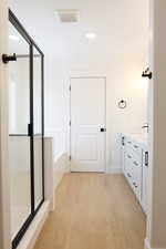 Bathroom featuring vanity, wood-type flooring, and shower with separate bathtub