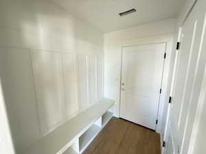 Mud bench, garage door, and door to half bathroom.