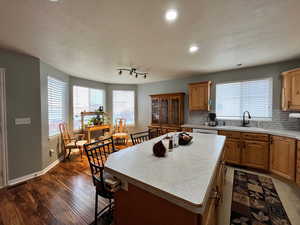 Kitchen featuring tasteful backsplash, sink, a kitchen island, and dark hardwood / wood-style flooring