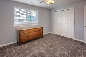 Bedroom with a closet, carpet, and ceiling fan