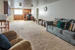 Living room with carpet flooring and a textured ceiling