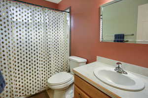 Bathroom featuring vanity, toilet, and a shower with shower curtain