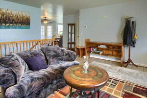 Living room with french doors, light tile patterned floors, and ceiling fan