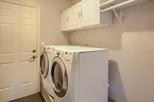 Laundry room featuring cabinets and washing machine and clothes dryer