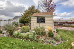 View of outdoor structure featuring a lawn