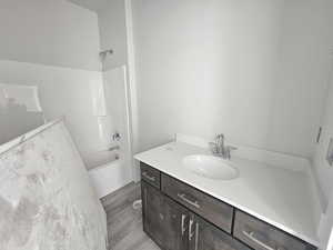 Bathroom featuring vanity, shower / washtub combination, and hardwood / wood-style floors