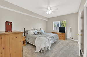 Carpeted bedroom featuring ceiling fan