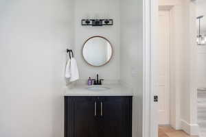 Bathroom featuring vanity, a notable chandelier, and hardwood / wood-style floors