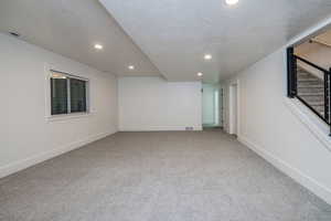 Carpeted spare room featuring a textured ceiling