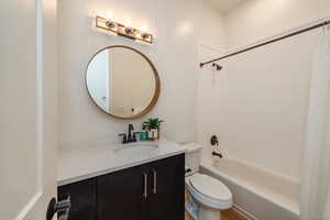 Full bathroom featuring vanity, toilet, hardwood / wood-style flooring, and shower / bath combo with shower curtain