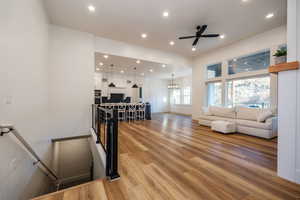 Living room featuring hardwood / wood-style flooring and ceiling fan with notable chandelier